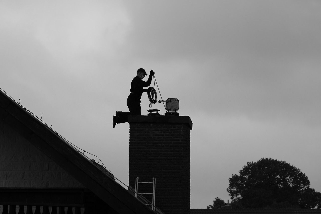 A Professional Chimney Specialist on a Home Roof, Engaged in Chimney Cleaning